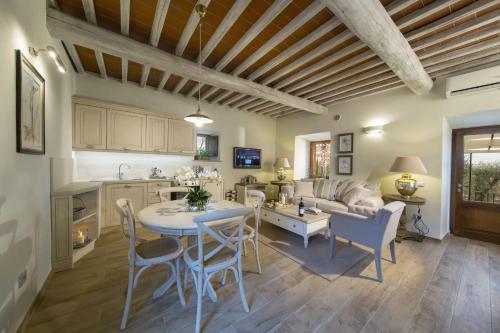 a kitchen and living room with a table and chairs at Borgo Argiano in Castelnuovo Berardenga