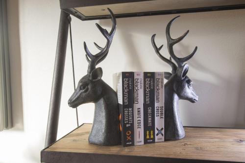 a shelf with two deer heads and two books at Borgo Argiano in Castelnuovo Berardenga
