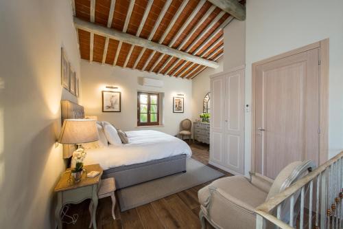 a bedroom with a large bed and a staircase at Borgo Argiano in Castelnuovo Berardenga