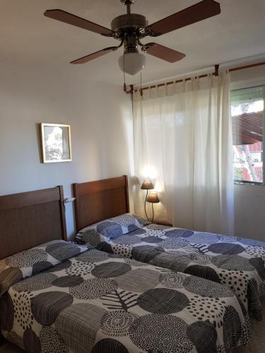 ラ・マンガ・デル・マール・メノールにあるTorre Exagonalのシーリングファン付きのベッドルーム1室(ベッド2台付)