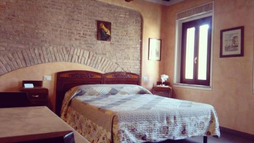 a bedroom with a bed and a brick wall at Corte Pioppazza in Ceresara