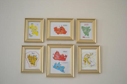 four framed maps of different countries on a wall at INNI Homestay in Malang