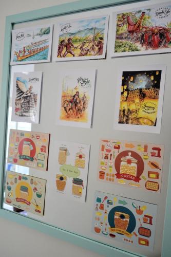 a wall with posters and pictures on it at INNI Homestay in Malang
