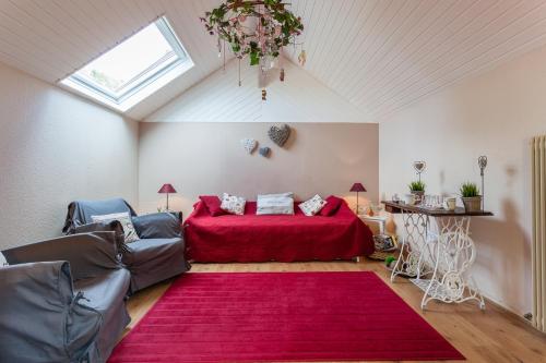 Wintzenheim-KochersbergにあるLa Rose Trémièreの赤いベッドと赤い敷物が備わるベッドルーム1室が備わります。