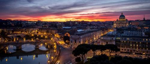 a view of a city at sunset with a bridge at Five Rooms Rome Guesthouse in Rome