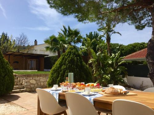 a wooden table with food on it in a garden at B&B Villa Pinos Málaga in Alhaurín de la Torre