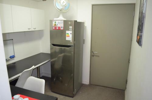 a stainless steel refrigerator in a kitchen with a door at Parque Arauco Departamento Estudio Las Condes in Santiago