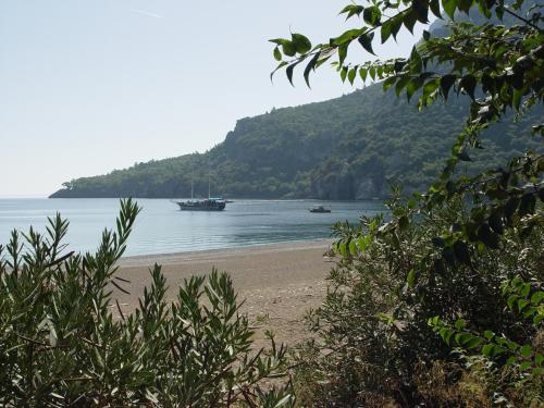 a beach with two boats in the water at Hotel Yavuz Bungalow in Cıralı