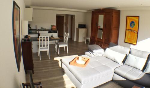 ein Wohnzimmer mit einem weißen Sofa und einer Küche in der Unterkunft Ferienwohnung An der Pferdsweide in Trier