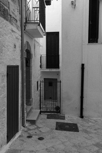 a black and white photo of an alley with a gate at A sud Holiday House in Polignano a Mare