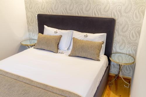 a white bed with two pillows and two tables at Formosa 178 by Guestify in Porto