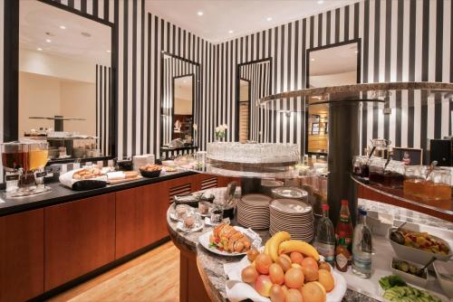 a restaurant with a buffet with plates of food at Best Western Plus Hotel Excelsior in Erfurt