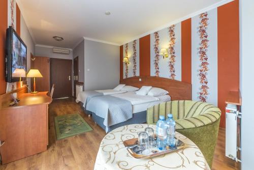 a hotel room with a bed and a table at Hotel Doris in Oborniki