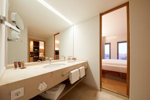 ein Badezimmer mit einem Waschbecken und einem großen Spiegel in der Unterkunft Hotel Rittergut Stoermede in Geseke