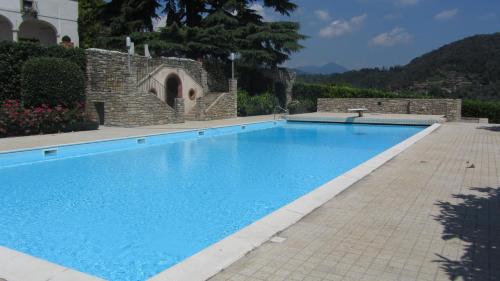 a large blue swimming pool in a yard at Castello degli Angeli in Carobbio degli Angeli