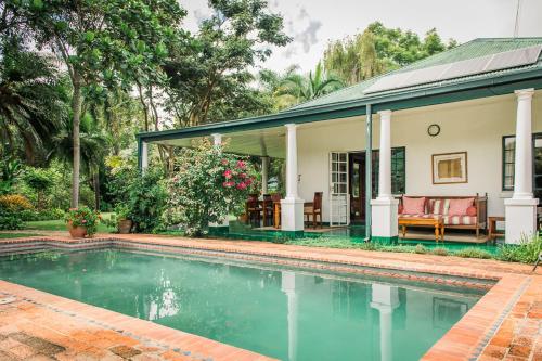 una casa con piscina frente a ella en York Lodge, en Harare