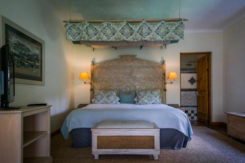 a bedroom with a large bed with a canopy at York Lodge in Harare