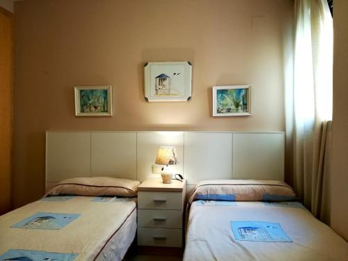 ein Schlafzimmer mit 2 Betten und einem Tisch mit einer Lampe in der Unterkunft Atico Duplex con parking propio in Peñíscola