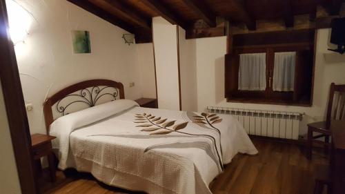 a bedroom with a bed with white sheets and a window at Hotel Restaurante La Parra in La Franca