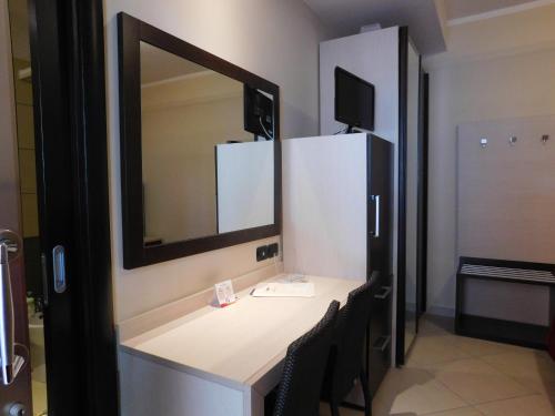 a bathroom with a vanity with a mirror and chairs at Hotel Risberg in Gallipoli