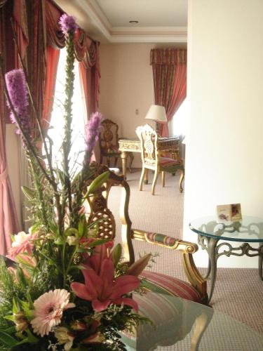 a living room with a table and a vase of flowers at Mansion del Cupatitzio in Uruapan del Progreso