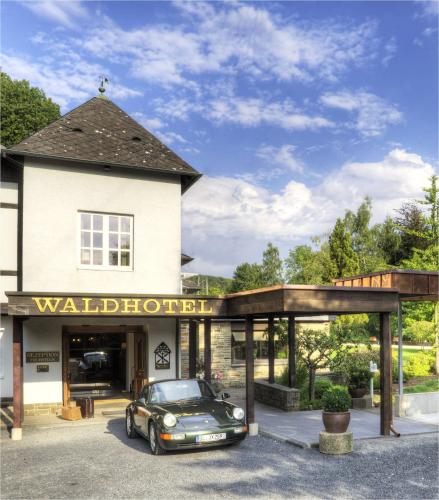 a car parked in front of a toll house at Romantik Waldhotel Mangold in Bergisch Gladbach