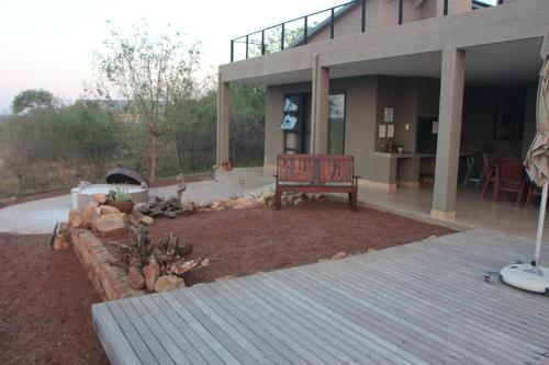 a patio with a bench in front of a house at Crocodile Bend in Mpakeni