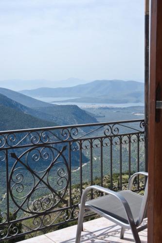 a chair sitting on a balcony with a view at Hermes Delphi Hotel in Delfoi