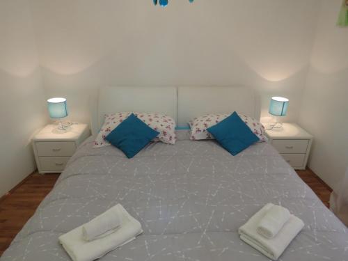 a bedroom with a large bed with blue pillows at Apartman Luna in Šibenik