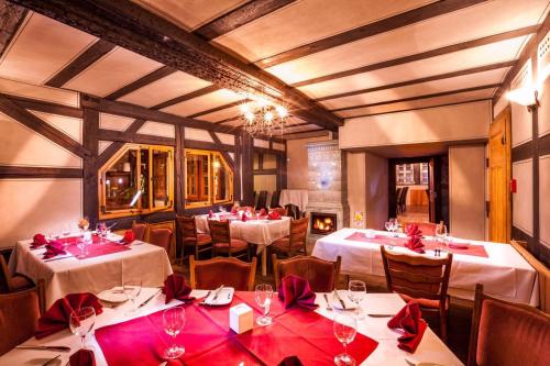 uma sala de jantar com mesas e cadeiras com arcos vermelhos em Hotel Haus im Sack em Jena