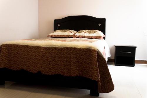a bedroom with a bed with a black headboard at Hotel LB - Los Balsos in Pasto