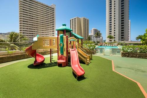 a playground with two slides on the grass at Hawaiian Sun Holidays in Honolulu