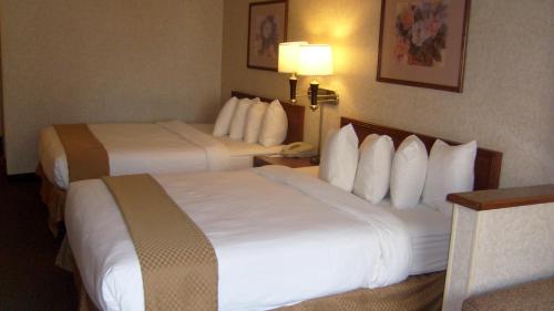 a hotel room with two beds and a lamp at Baymont by Wyndham Golden/Red Rocks in Lakewood