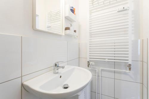 een witte badkamer met een wastafel en een douche bij Family Studio Apartment for 4 in Berlijn