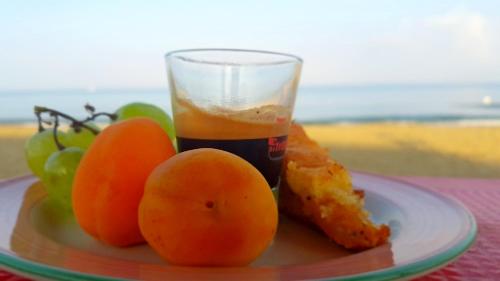 a plate of food with oranges and a glass of juice at Hotel Villa Tramonto direttamente sul mare in San Vincenzo