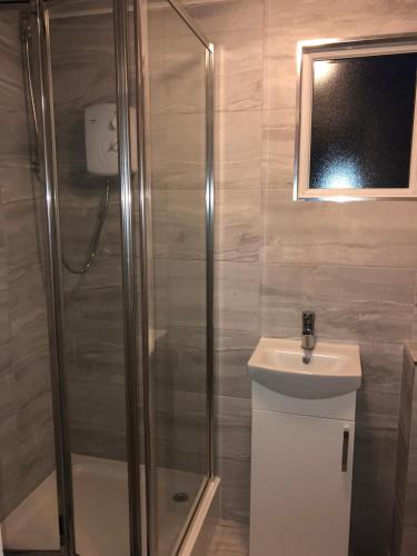 W łazience znajduje się prysznic i umywalka. w obiekcie California Chalet & Touring Park w mieście Wokingham