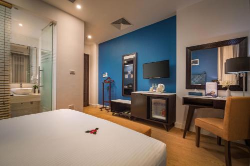 a bedroom with a bed and a desk and a television at Hanoi Brilliant Hotel & Spa in Hanoi