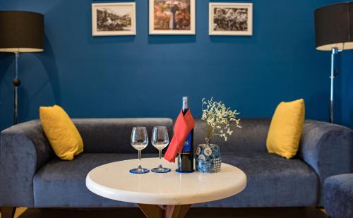 a living room with a couch and two wine glasses at Hanoi Brilliant Hotel & Spa in Hanoi