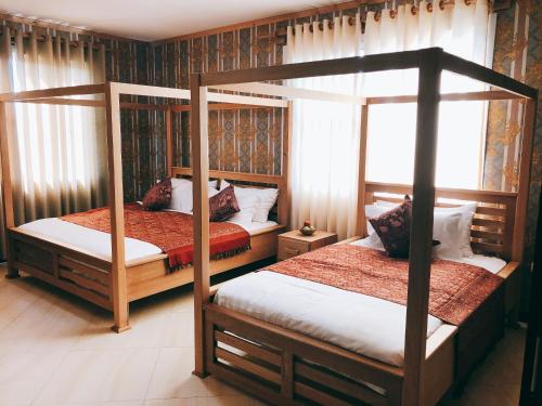 a bedroom with two bunk beds and a window at Hotel Duomo and Suites in Kampala