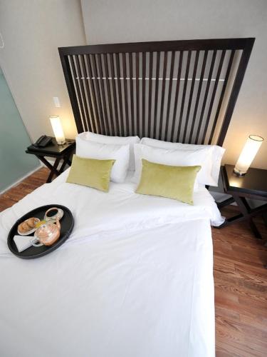 a large white bed with a tray of food on it at Patios de San Telmo in Buenos Aires