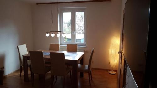 a dining room table with chairs and a window at Ferienwohnung am Hang in Ettenheim