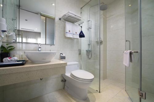 a bathroom with a toilet and a glass shower at Hanoi Brilliant Hotel & Spa in Hanoi