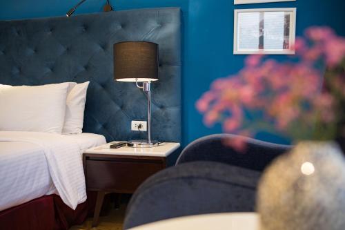 a hotel room with a bed and a lamp on a table at Hanoi Brilliant Hotel & Spa in Hanoi