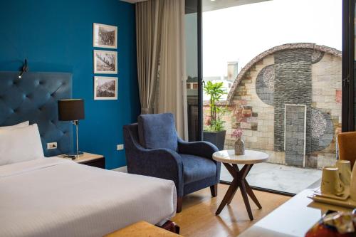 a hotel room with a bed and a chair and a window at Hanoi Brilliant Hotel & Spa in Hanoi