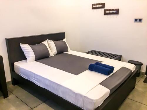 HomagamaにあるUS Motel Colomboの黒と白のベッドバイザー付きの客室のベッド1台分です。