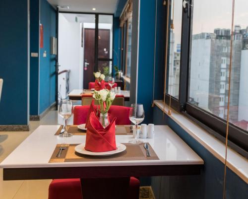 a restaurant with a table with a vase of flowers at Hanoi Brilliant Hotel & Spa in Hanoi