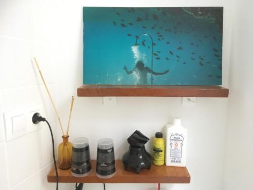 a painting of a man under the water on a shelf at Casinha Azul in Horta
