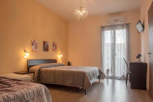 Campobello di LicataにあるAsaro Camereのベッドルーム1室(ベッド2台、窓付)