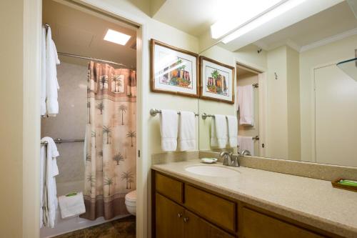uma casa de banho com um lavatório e um chuveiro em Sweetwater at Waikiki, VRI Americas em Honolulu