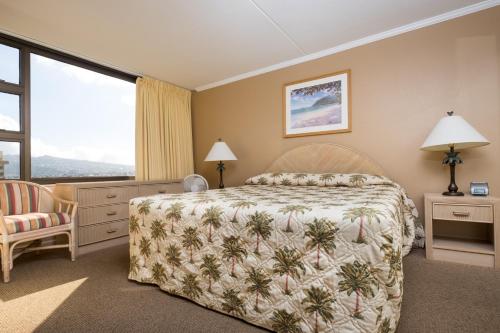 a bedroom with a bed and a large window at Sweetwater at Waikiki, VRI Americas in Honolulu